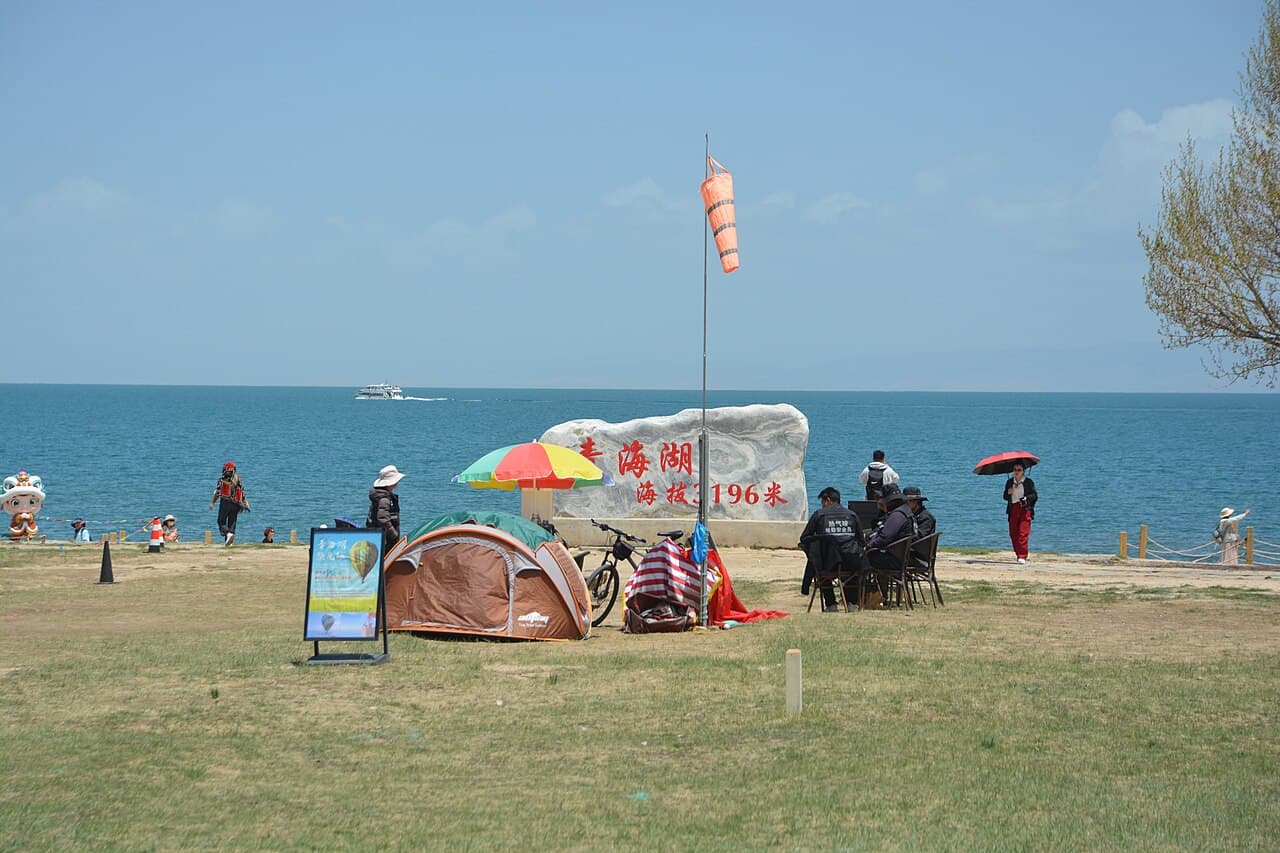 「青海湖·海拔 3196 米」石碑旁的湖畔草地